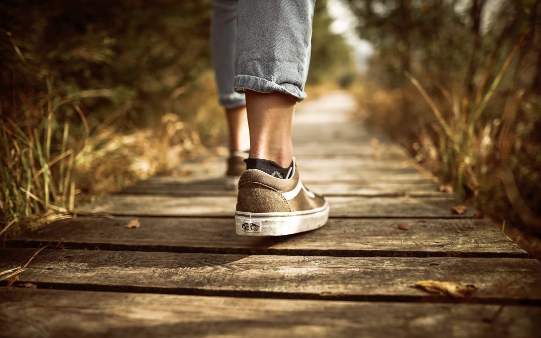 feet in sneakers walking down a beautiful outdoor path