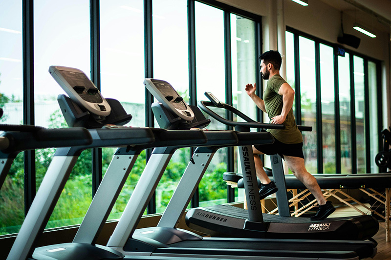 man running on a treadmill in a gym setting