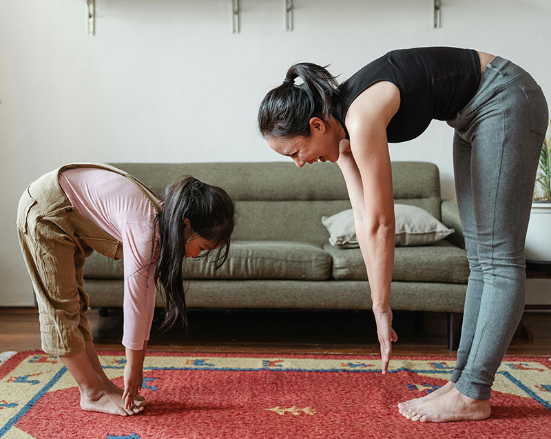 asian mother and daughter touching toes